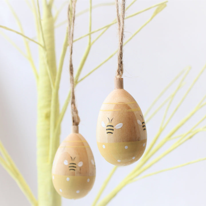 Ensemble de trois oeufs de Pâques en bois avec des abeilles