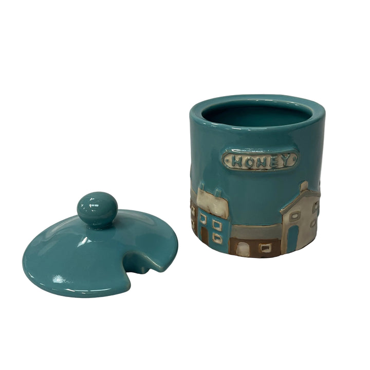 Teal ceramic honey jar with lid on a white background